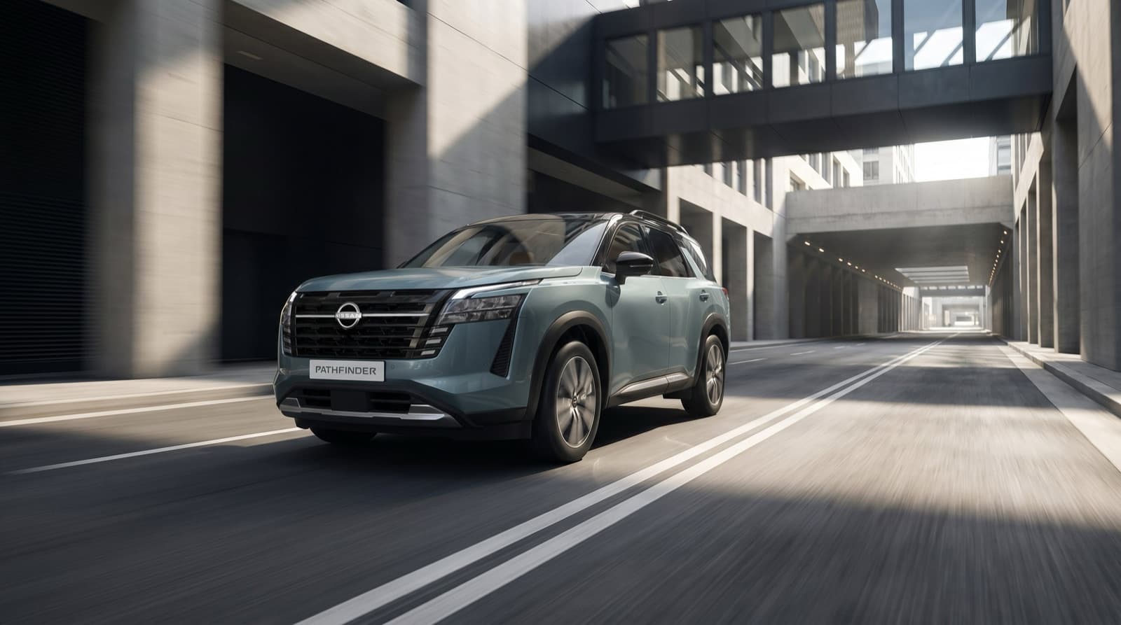 Refreshed 2026 Nissan Pathfinder in Grayish Turquoise with a black roof, driving through a concrete city underpass